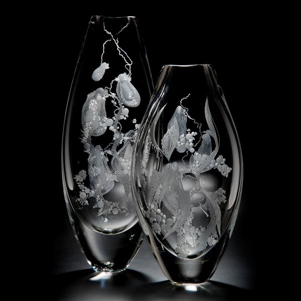 two clear glass vases with engraved flower patterns