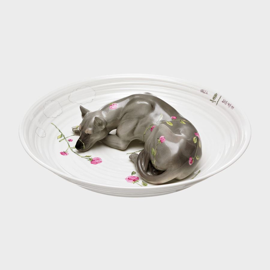 porcelain sculpted bowl in white with porcelain sculpted model of a dog resting in the centre