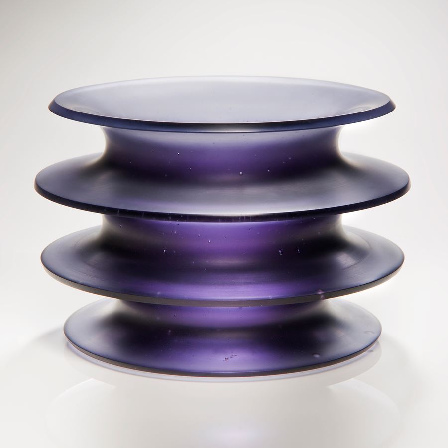 purple glass sculpture with four protruding rings