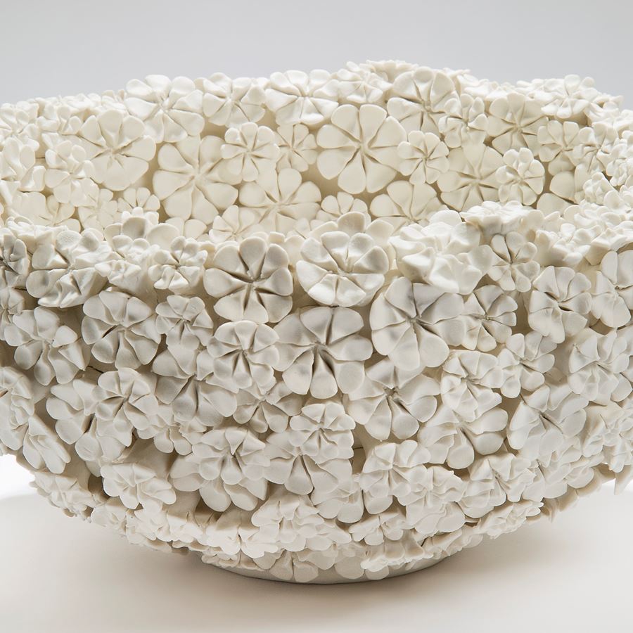 white porcelain bowl sculpture in the shape of many small daisies in white
