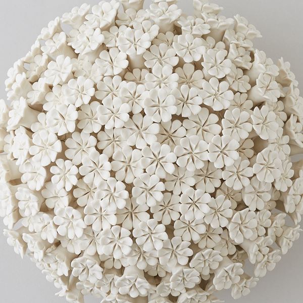 white porcelain sculpture of daisies arranged in sphere