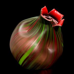 art glass sculpture resembling a nut in dark brown with green trim and red top