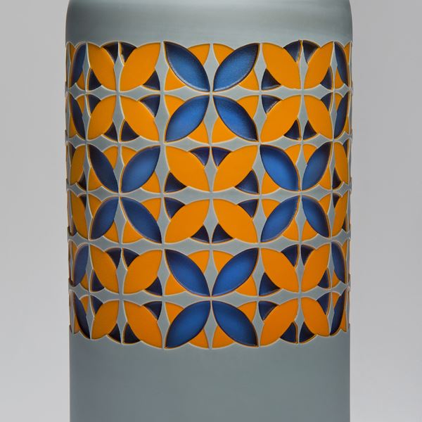 tall art glass sculpture in grey with orange and blue pattern
