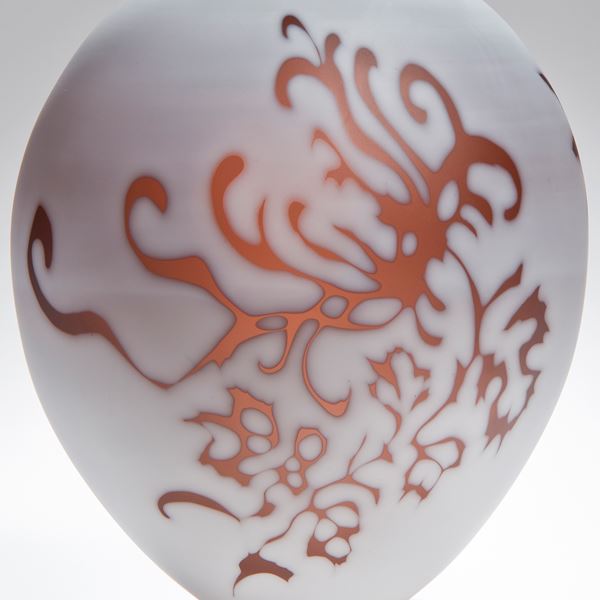 short round white cameo glass sculpture with orange floral motif