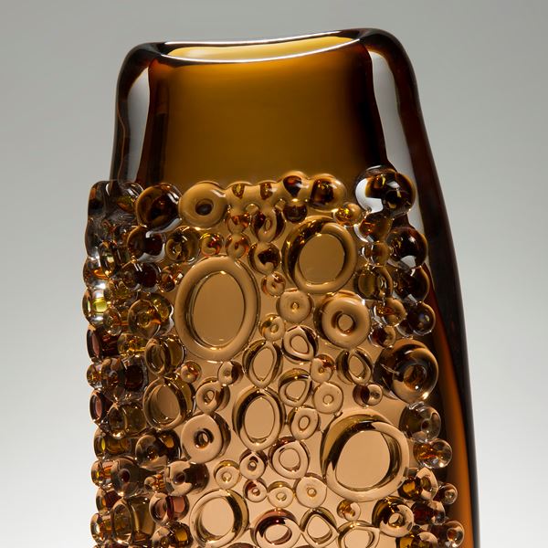 dark amber tall glass vessel sculpture with external circular crystals