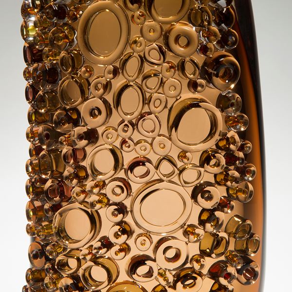 dark amber tall glass vessel sculpture with external circular crystals
