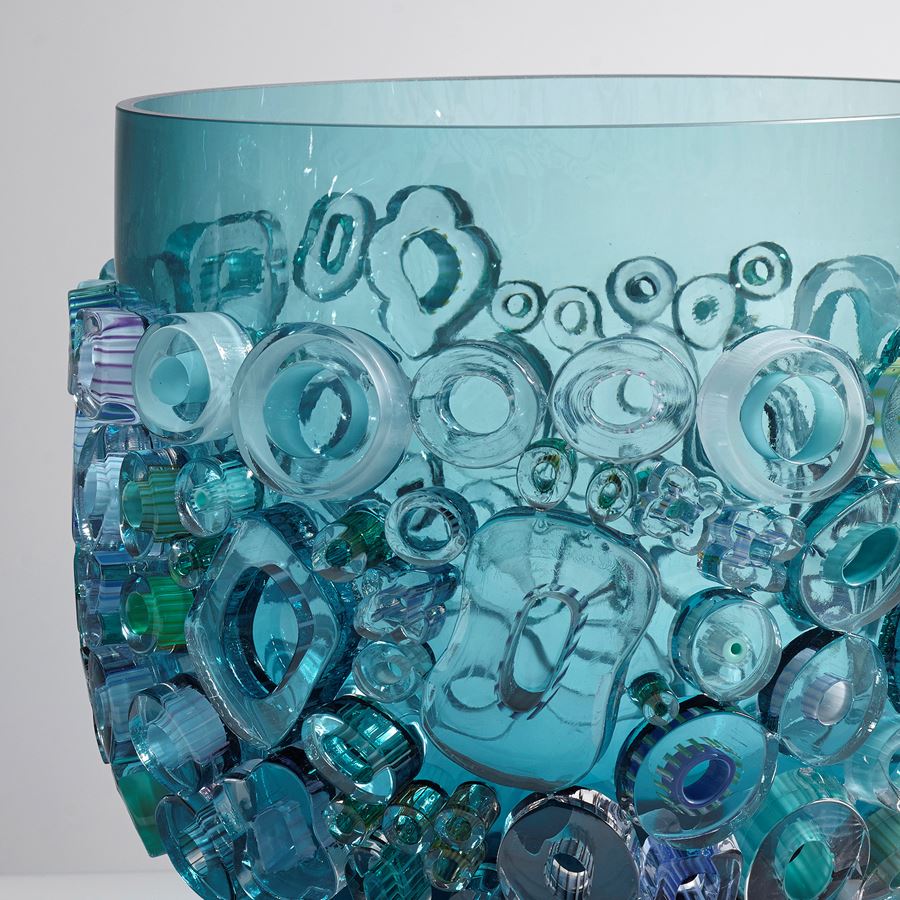 aqua blue coloured open glass vessel sculpture with busy external adornment