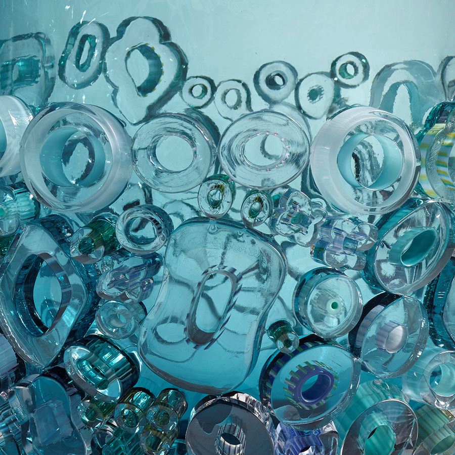 aqua blue coloured open glass vessel sculpture with busy external adornment