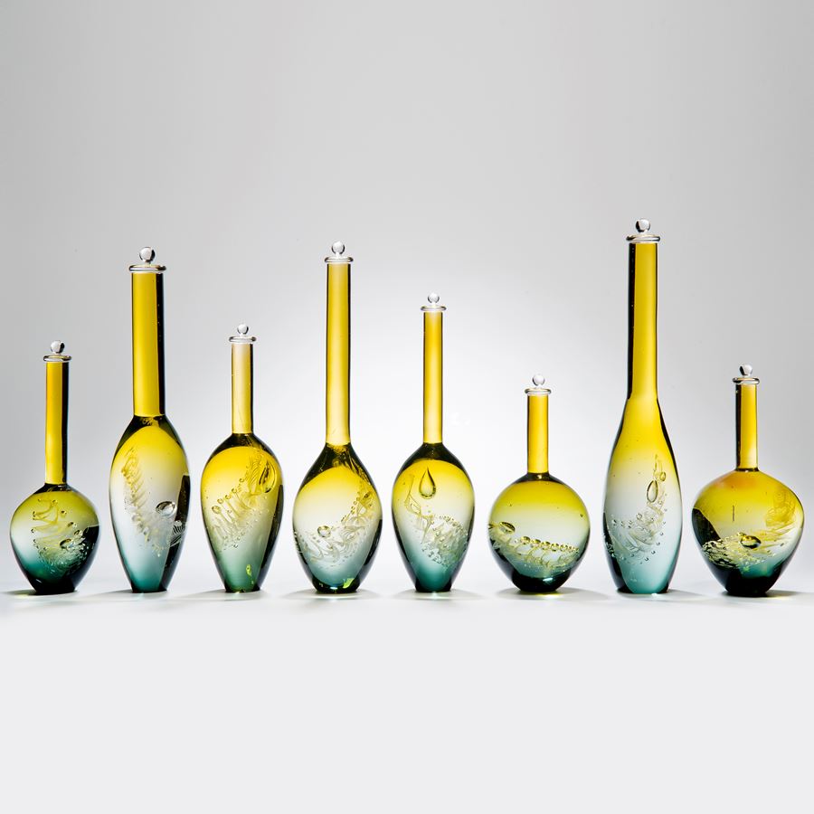 collection of eight handblown yellow and aqua glass vase sculptures with long necks in different sizes 