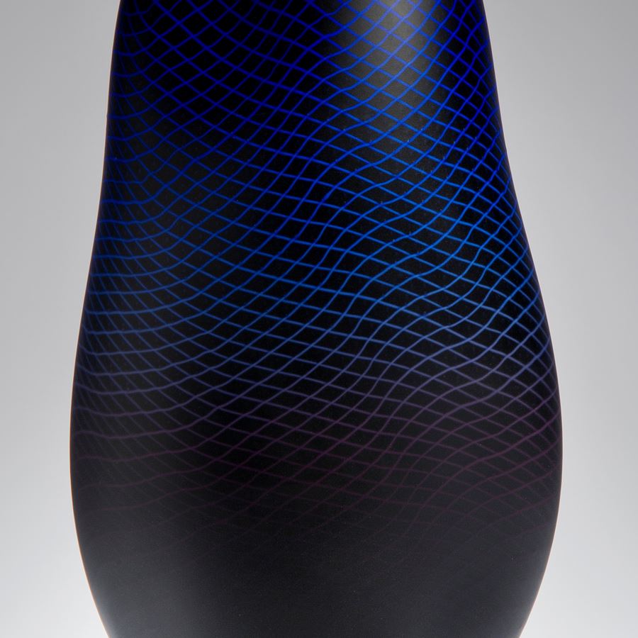 modern art glass sculptured vessel in dark blue with external geometric engraving