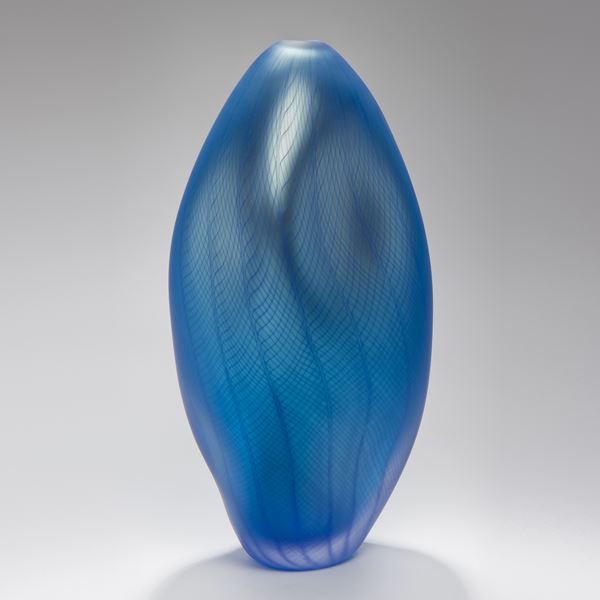 blue abstract vase like art glass sculpture with styled dent and patterned exterior