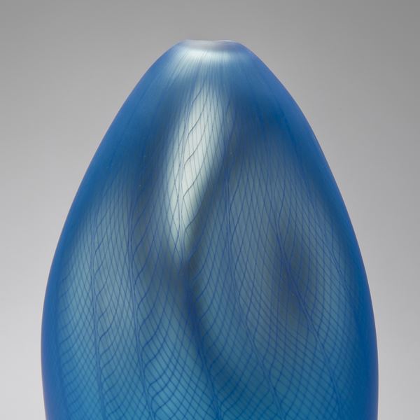 blue abstract vase like art glass sculpture with styled dent and patterned exterior