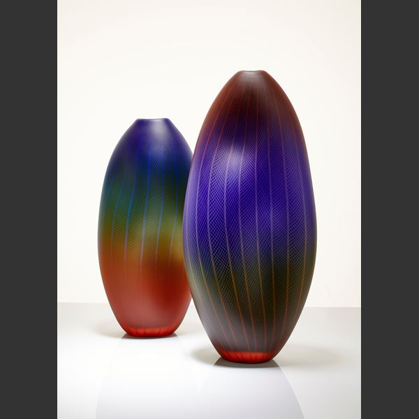 tall oblong blown glass vase in dark purple, red and black with lined and checked external engraving