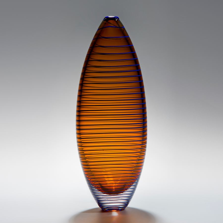 tall oval shaped amber vase sculpture with horizontal black lines