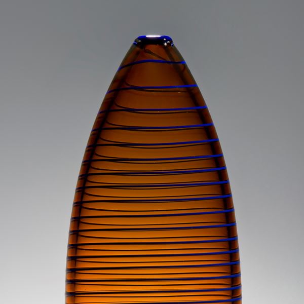 tall oval shaped amber vase sculpture with horizontal black lines
