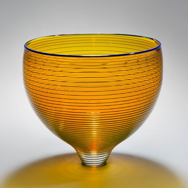 gold art glass bowl with thin black horizontal lines
