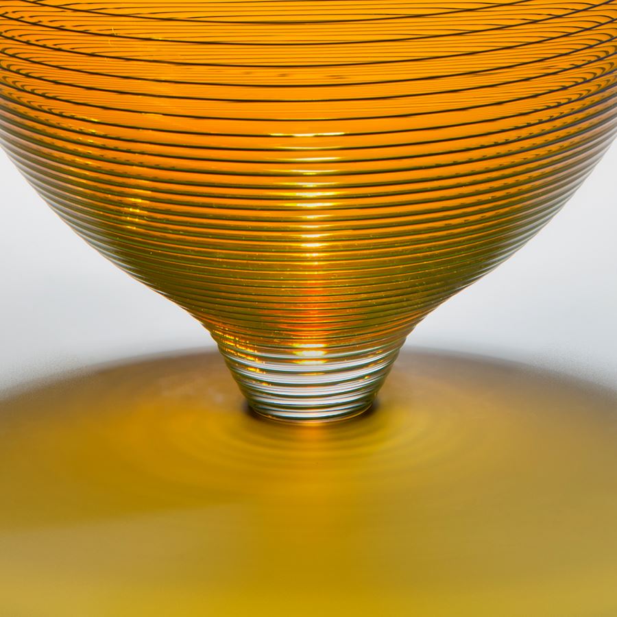 gold art glass bowl with thin black horizontal lines