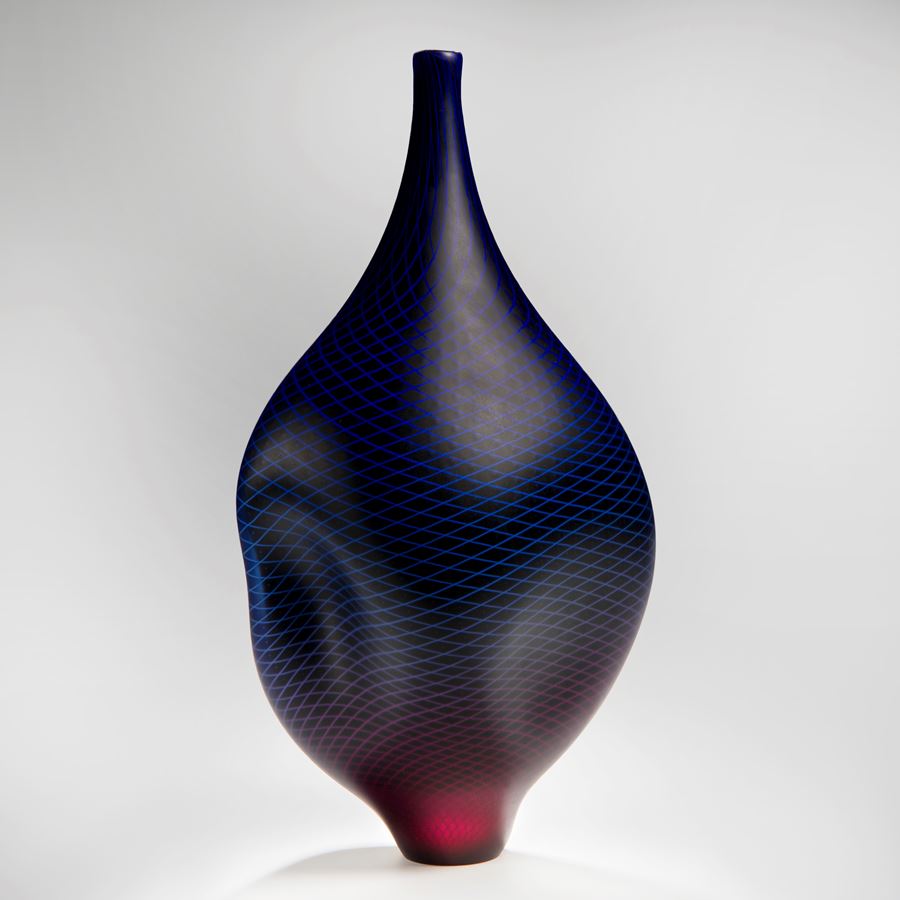 modern glass vase with wide midrift and narrow base and top in dark purple