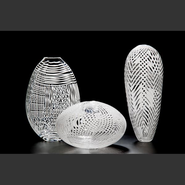 clear glass sculpted vessel with white patterned exterior