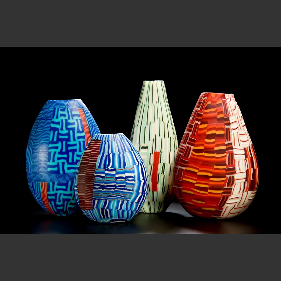 glass art vessel sculpture with blue and terracotta line patterns