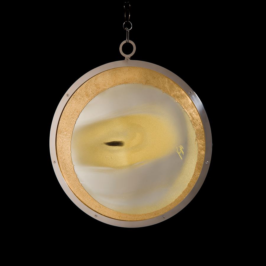 white and gold round art glass sculpture with faint resemblance to an eye on gold chain