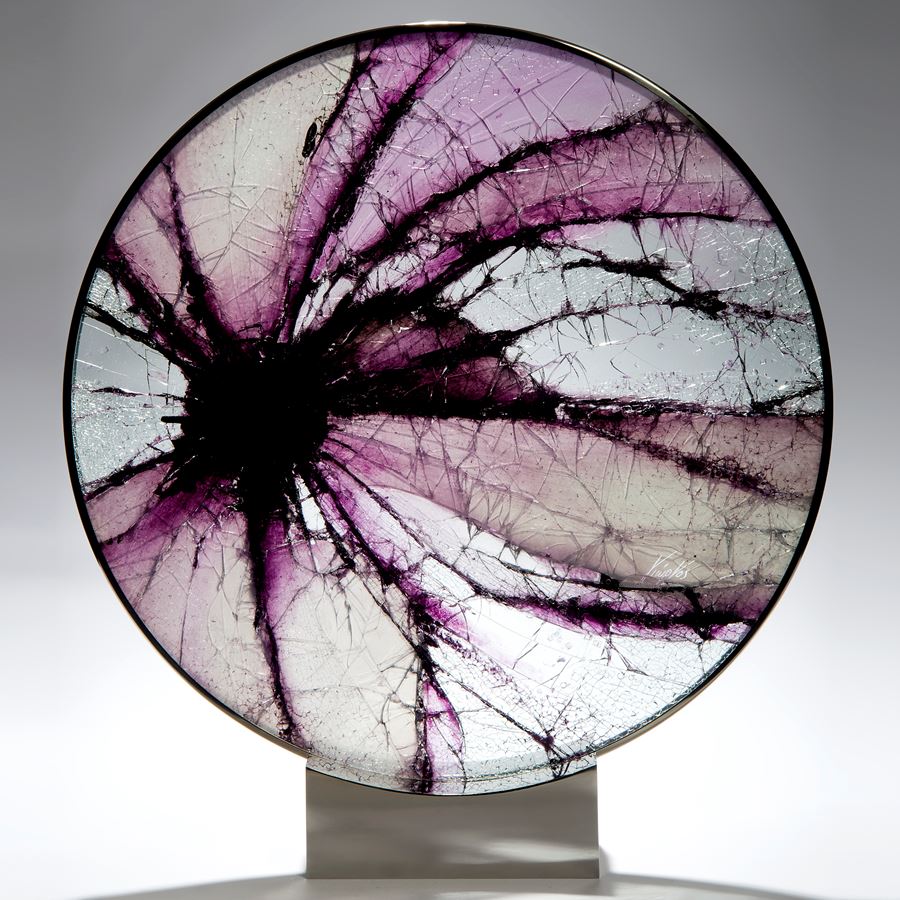 round art glass sculpture made from shattered pieces arranged in eye shape on steel base