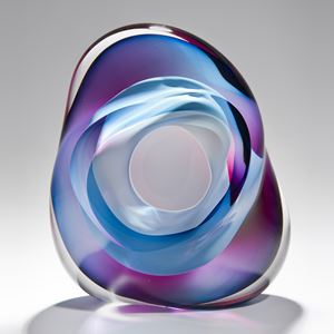 modern art glass sculpture in turquoise blue pink and purple with hole in centre
