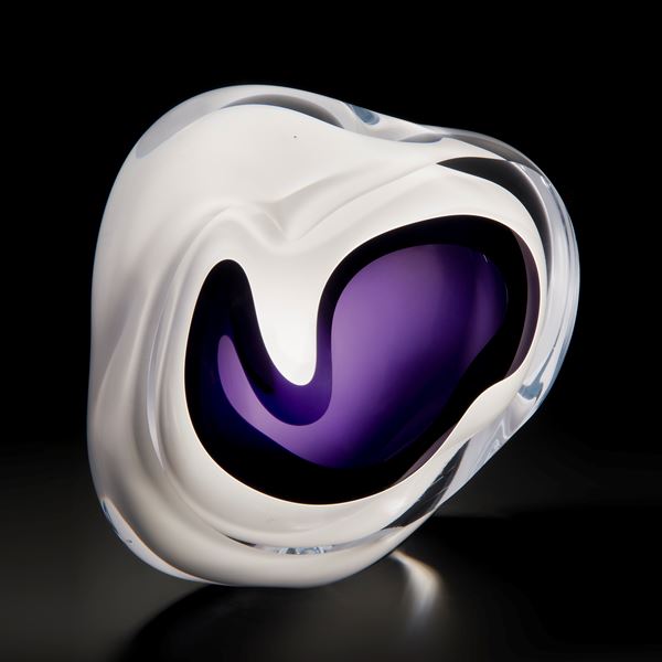 minimalist art glass sculpture of a rock in white with purple and black centre