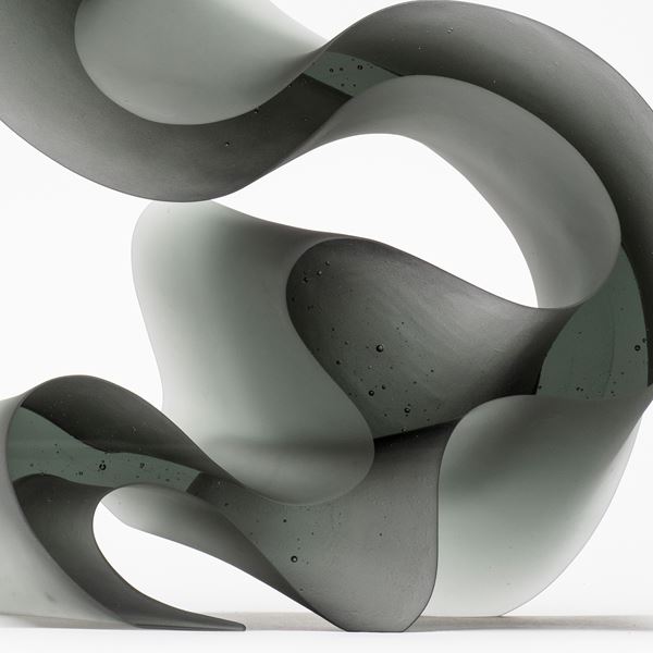 contemporary abstract glass art sculpture of swirly line in grey