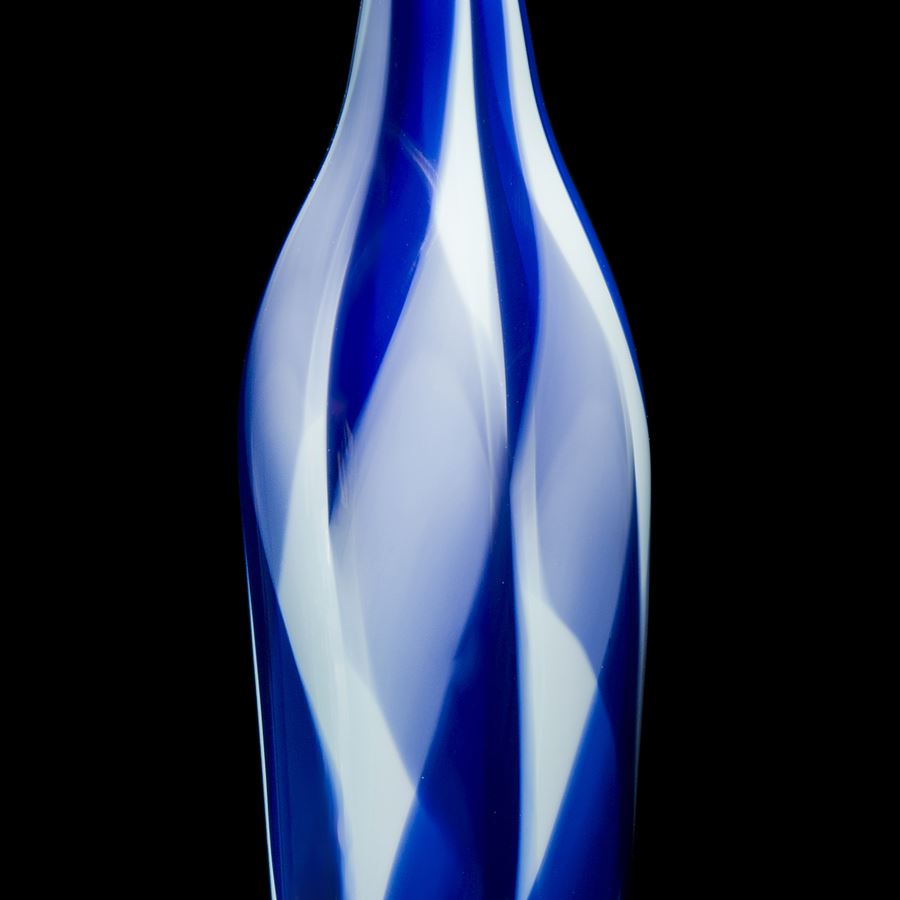 tall and thin bottle shaped decorative glass sculpture in shades of blue and white with thin neck