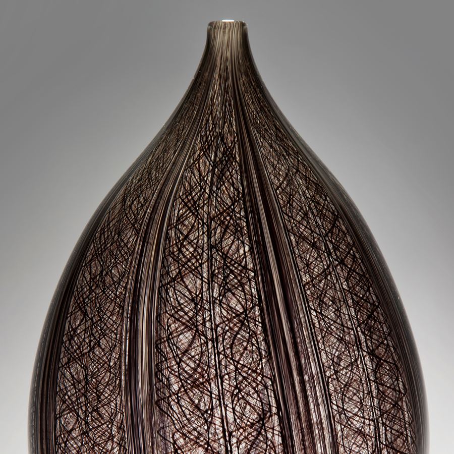 sculpted art-glass vase with wide base and narrow top with patterned exerior 