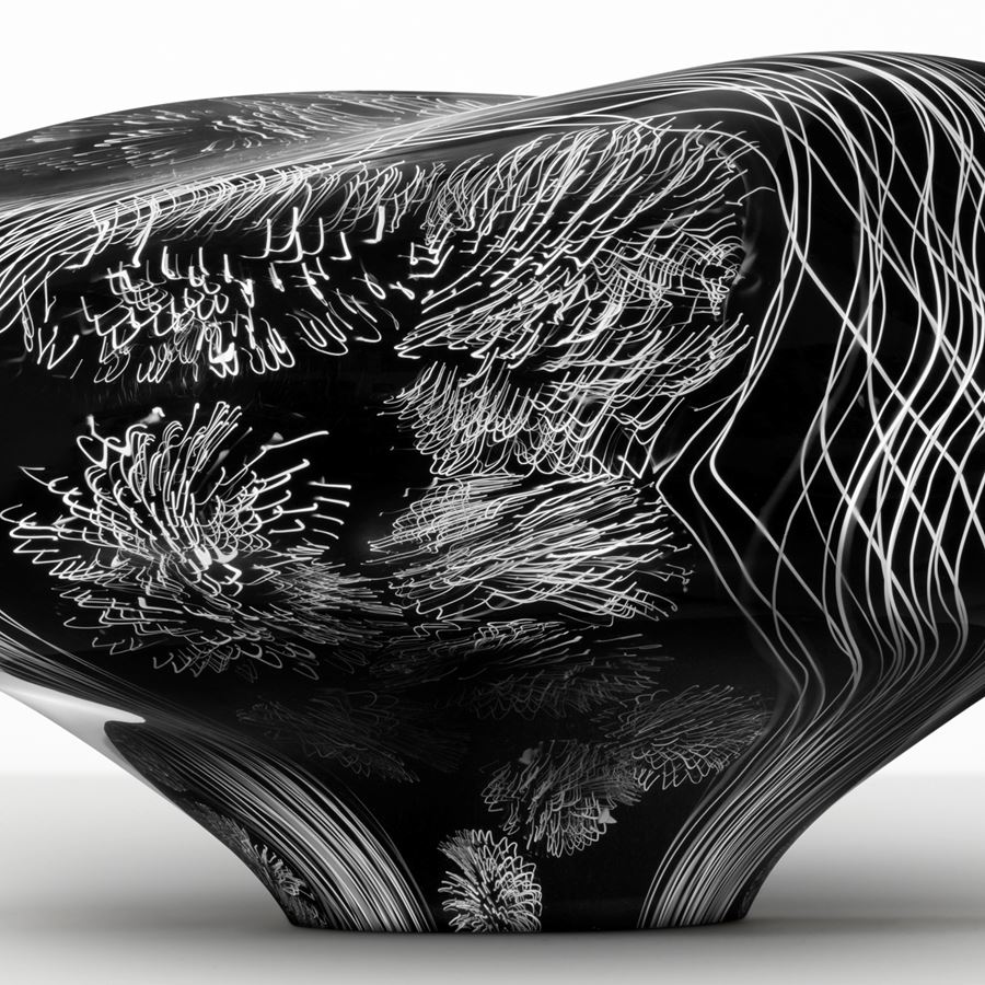 abstract brain-shaped clear glass sculpture in black with white etched patterning throughout 