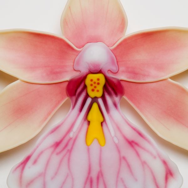 sculpted glass art of an exotic flower in white pink and yellow