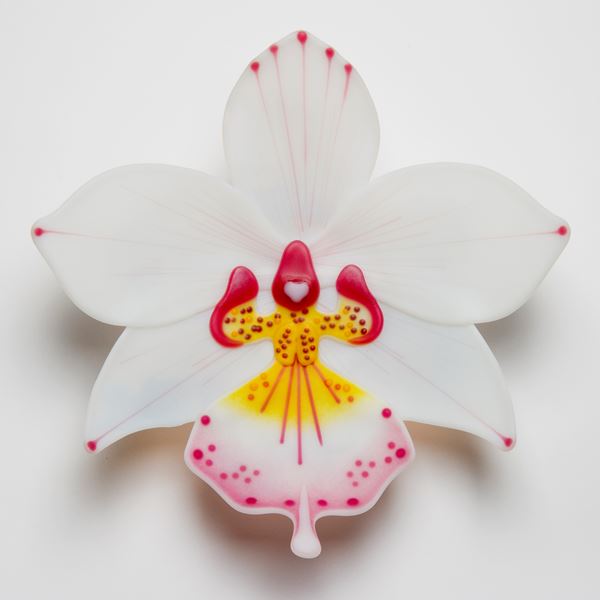 sculpted glass art of a white exotic flower with pink and yellow detail