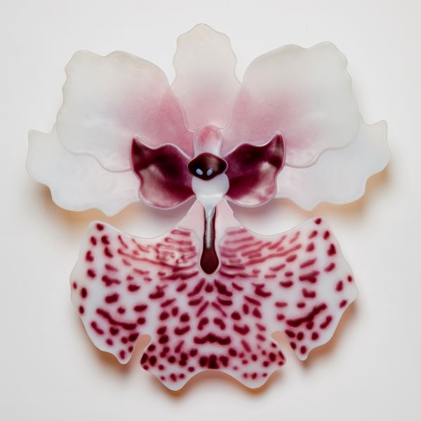 sculpted glass art of exotic flower in white with pink speckles and purple detail