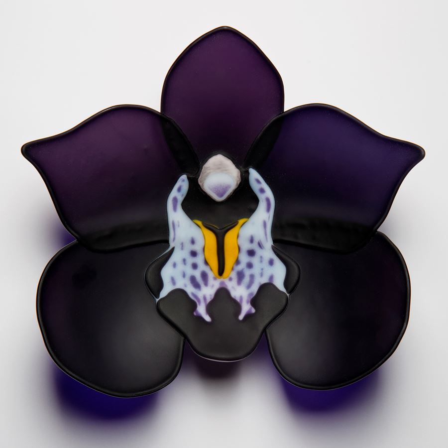 sculpted glass artwork of a black and dark purple flower with lighter detail in centre