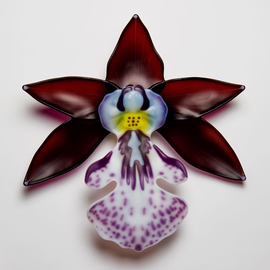 glass sculpture of exotic flower in burgandy white and purple speckles