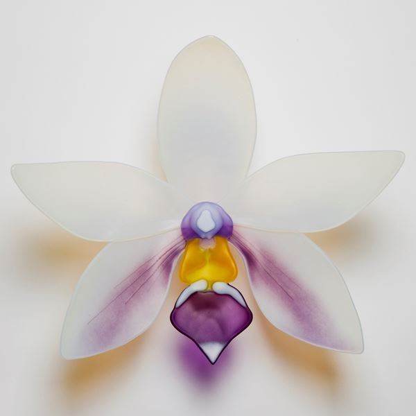 glass art sculpture of an exotic flower in white with purple detail