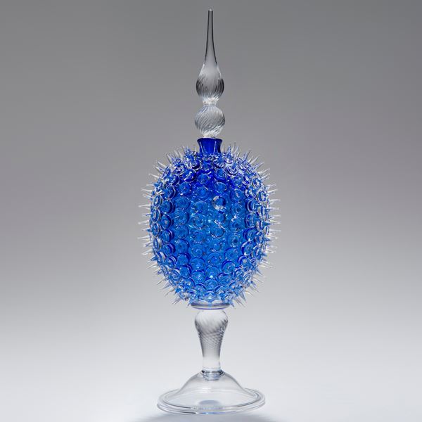 glass sculpture of spiked blue ball in the centre of clear glass base and top