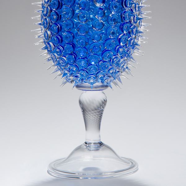 glass sculpture of spiked blue ball in the centre of clear glass base and top