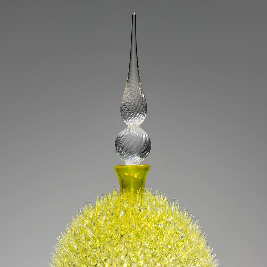 glass sculpture of spiked yellow ball in the centre of clear glass base and top