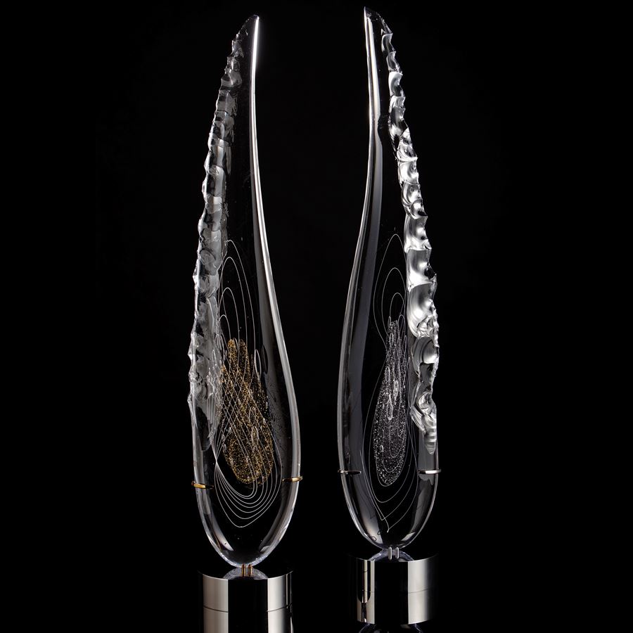 tall thin black art glass sculpture in the shape of a feather with hand chipped exterior gold patterns