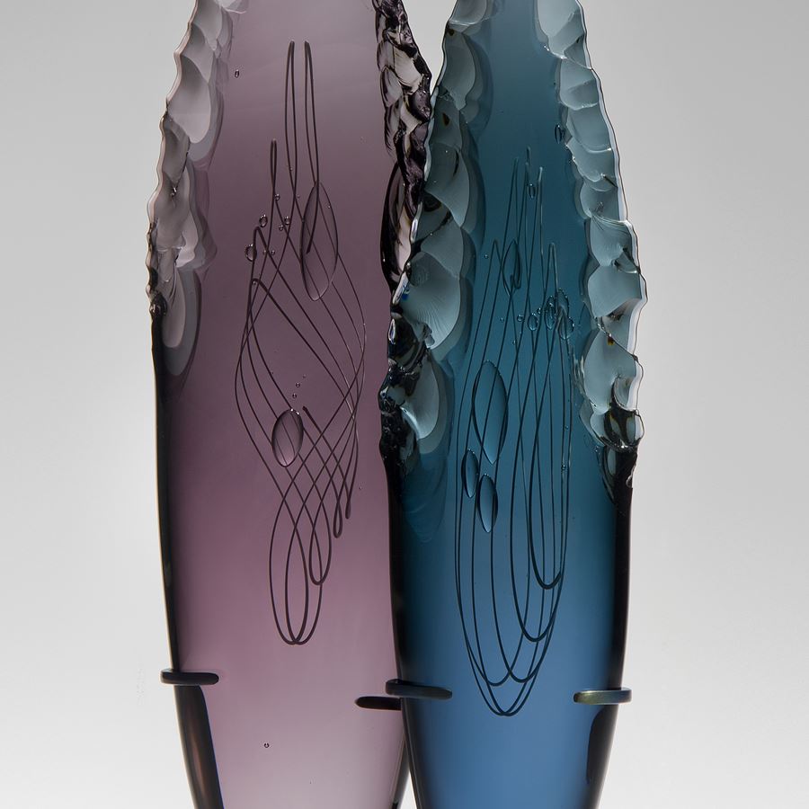 two plum and blue glass shard sculptures on black rectangular base