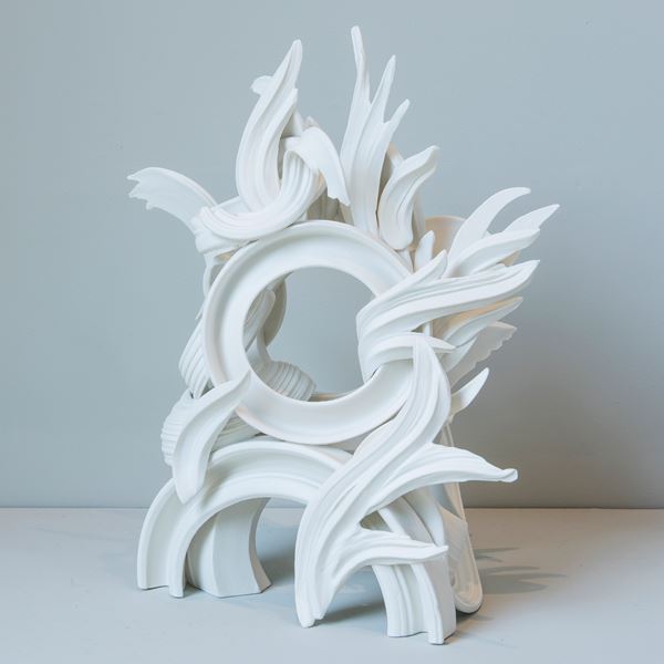 white porcelain sculpture in classical style of arcs and flares intertwined