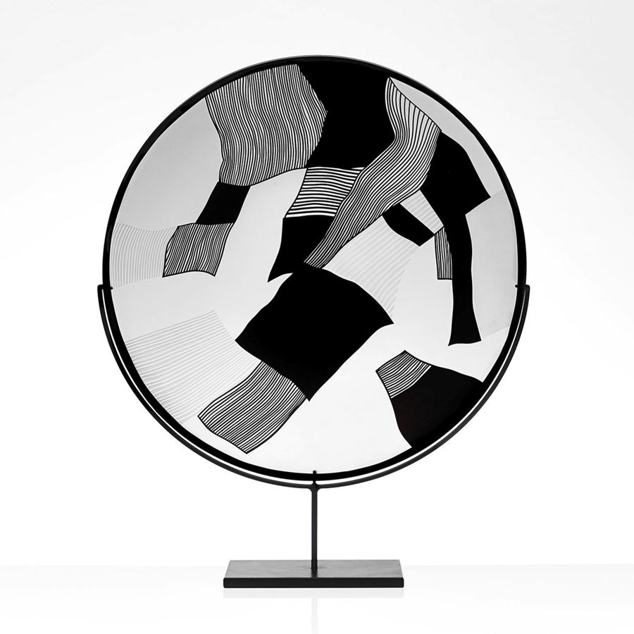 round modern glass art sculpture in black and white on steel stand