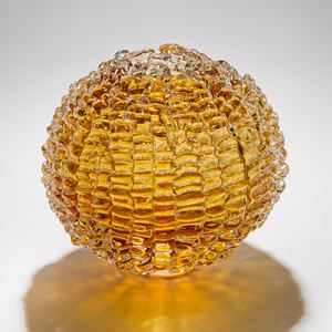 sphere shaped blown glass sculpture in amber made from stacked small shards