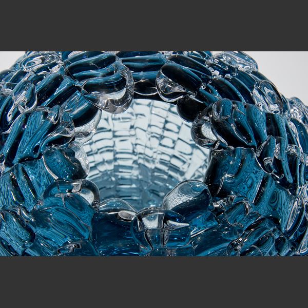 spherical hollow glass sculpture made from small rectangular pieces in light blue