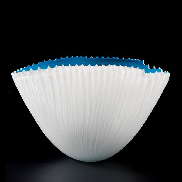 decorative hand cut art glass bowl with white exterior and blue interior 