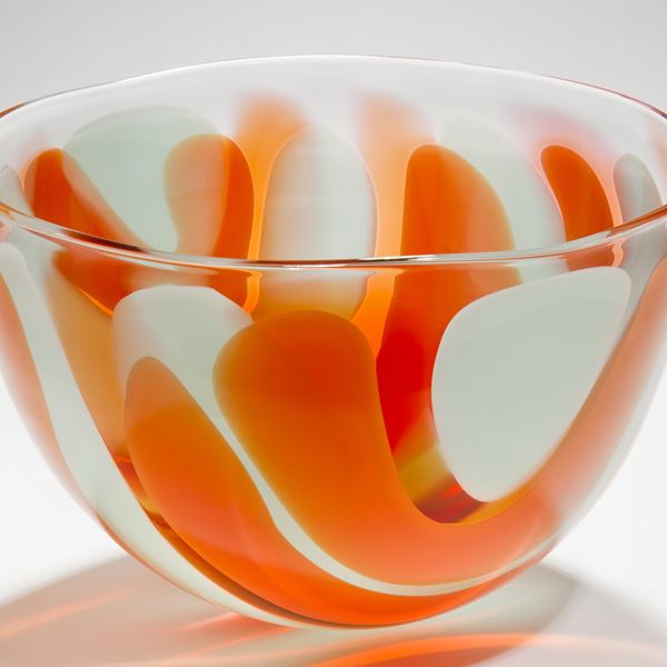 small bowl glass sculpture with orange and white swirls resembling colours of an egg