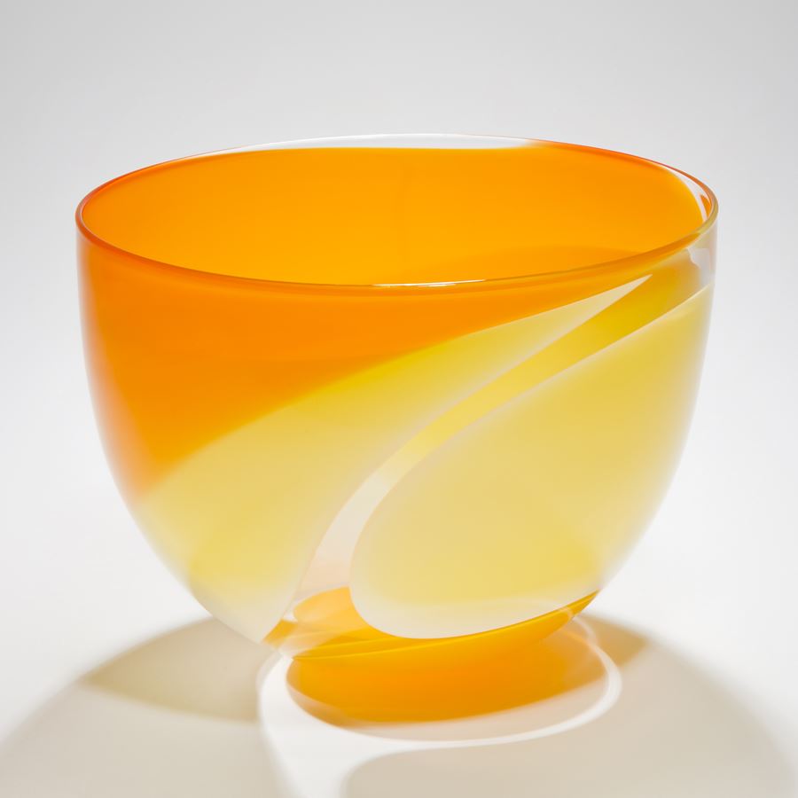 handblown glass sculpted bowl in orange with yellow waves